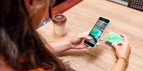 woman taking photograph of credit card