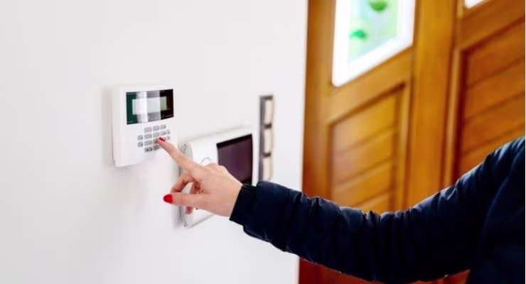 Woman setting security alarm