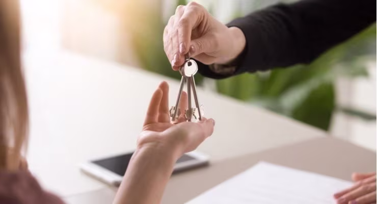 a man handing a woman a set of house keys 