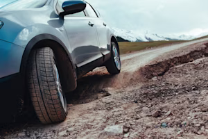 Car driving on damaged road with potholes
