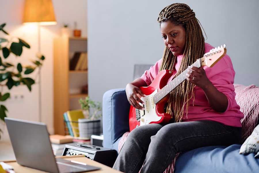 woman learning guitar at home