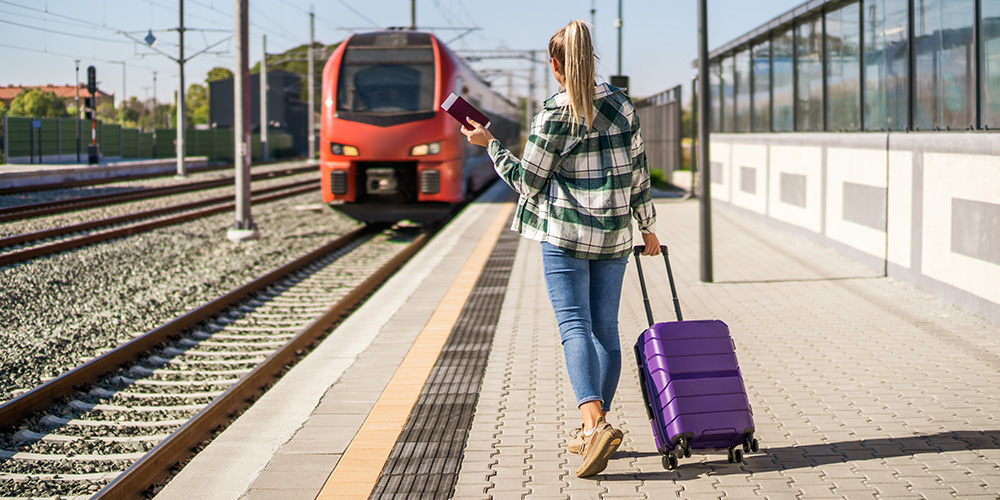 woman on train platform with suitcase