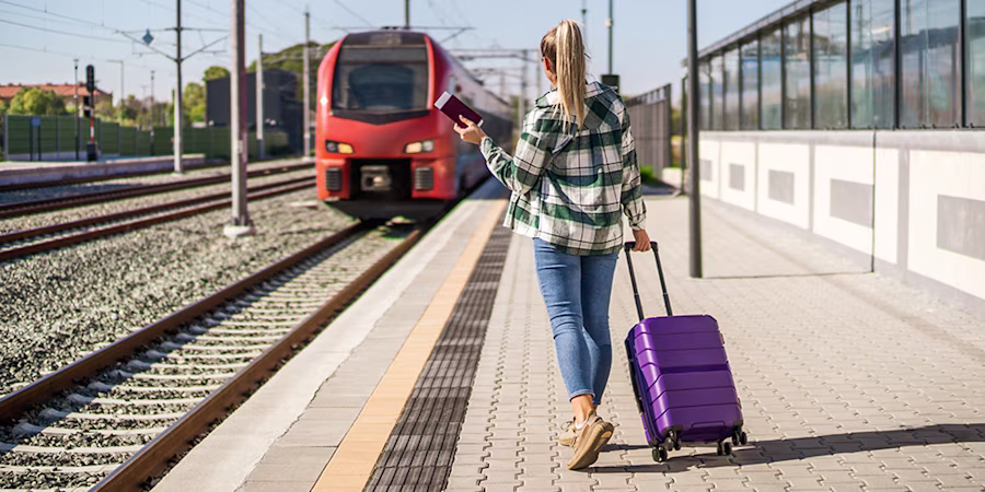 woman on train platform with suitcase