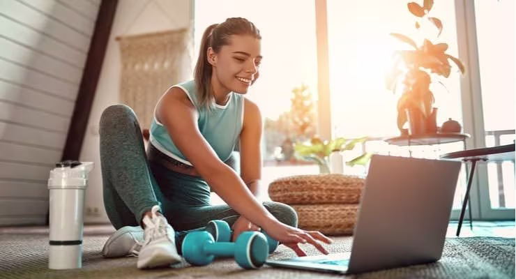 Girl using laptop in home whilst exercising