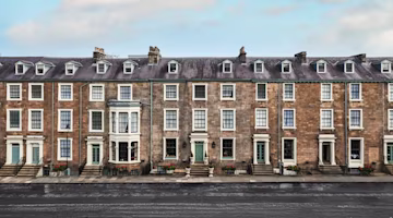 Woman on laptop with MoneySuperMarket logo displayed