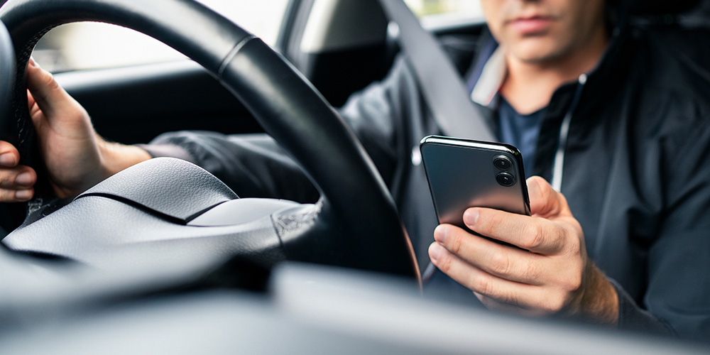 man using phone while driving