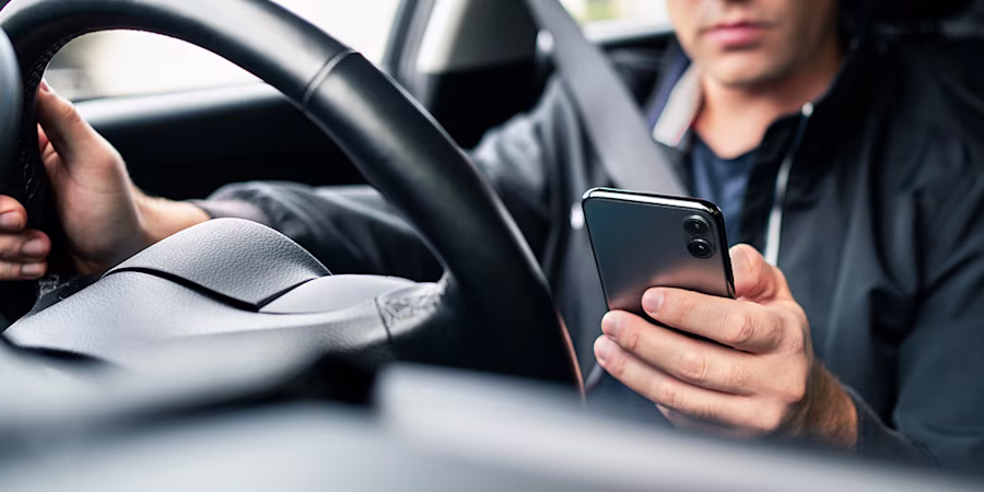 man using phone while driving