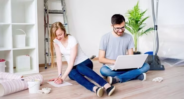 couple sitting on floor in empty flat