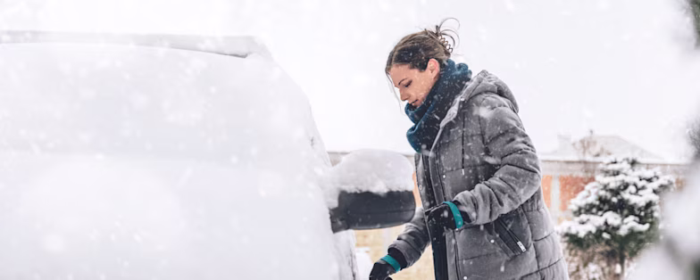 Woman with snow-covered car