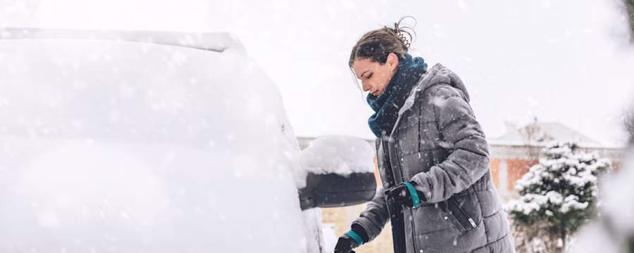 Woman with snow-covered car