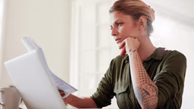 Woman on laptop with MoneySuperMarket logo displayed