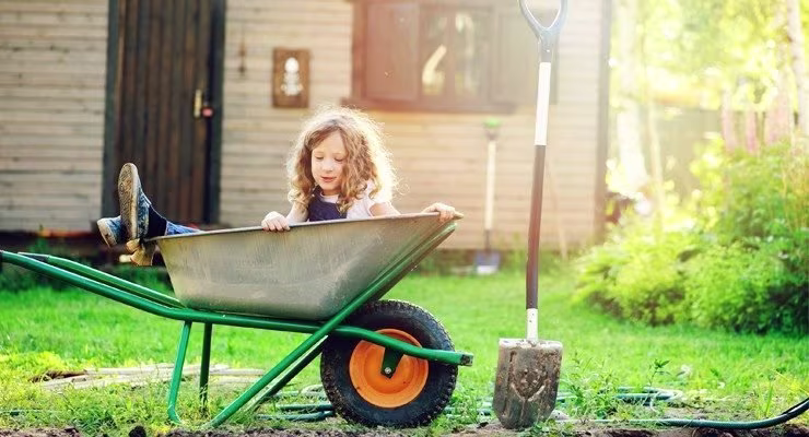child sitting in a wheelbarrow