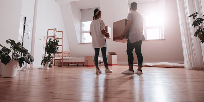 Couple carrying boxes with home contents inside