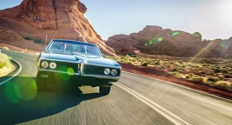 Two men in a car driving through mountains