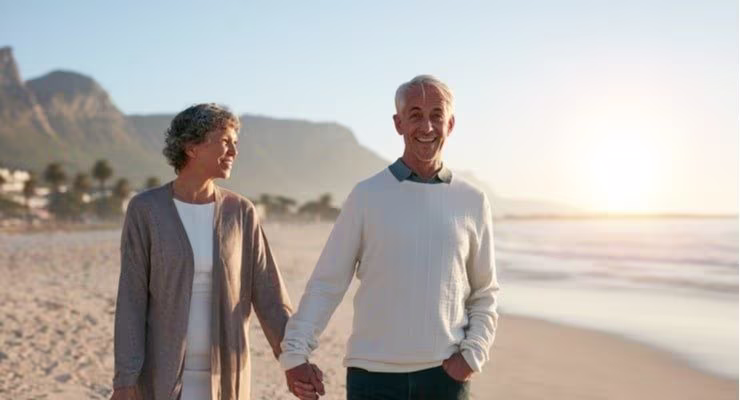 Older couple walking hand-in-hand on the beach