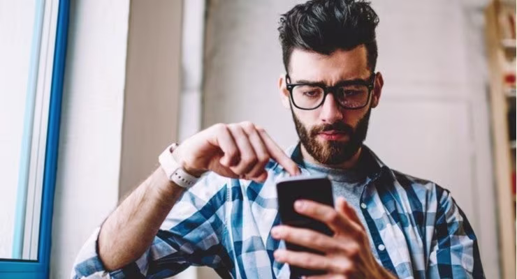 Man concentrating whilst looking at phone