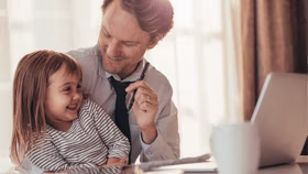 Father and daughter sitting at desk smiling