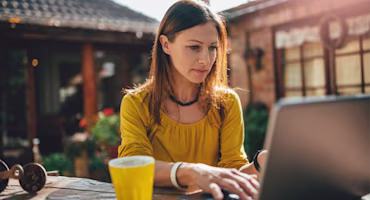 Woman on laptop with MoneySuperMarket logo displayed
