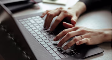 Woman on laptop with MoneySuperMarket logo displayed