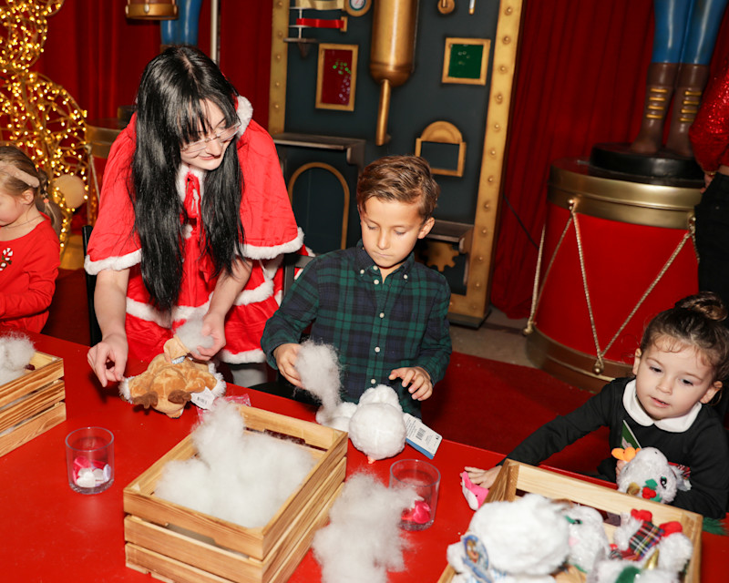 Family with children at a festive activity table at Passport to Santa