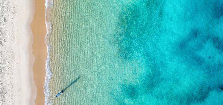 An aerial view photo of a beautiful exotic beach and water.