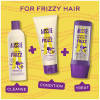 A picture of a shampoo bottle, conitioner, 3 minute miracle and a mask from calm the frizz collection.