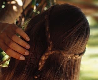 Picture of a woman with brown hair and one small braid on the back