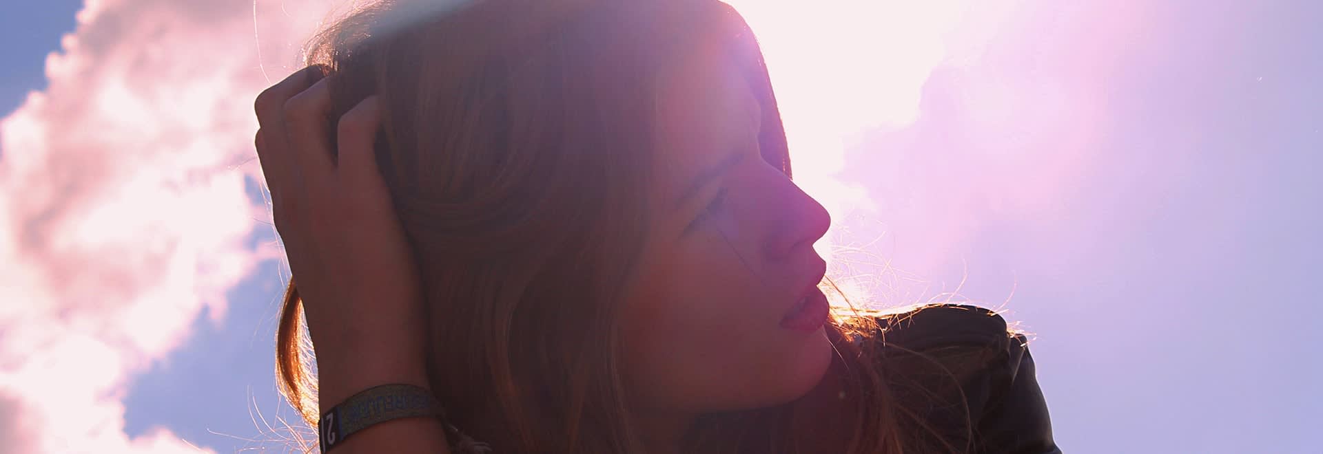 Portrait of a woman with blonde hair on colourful sky