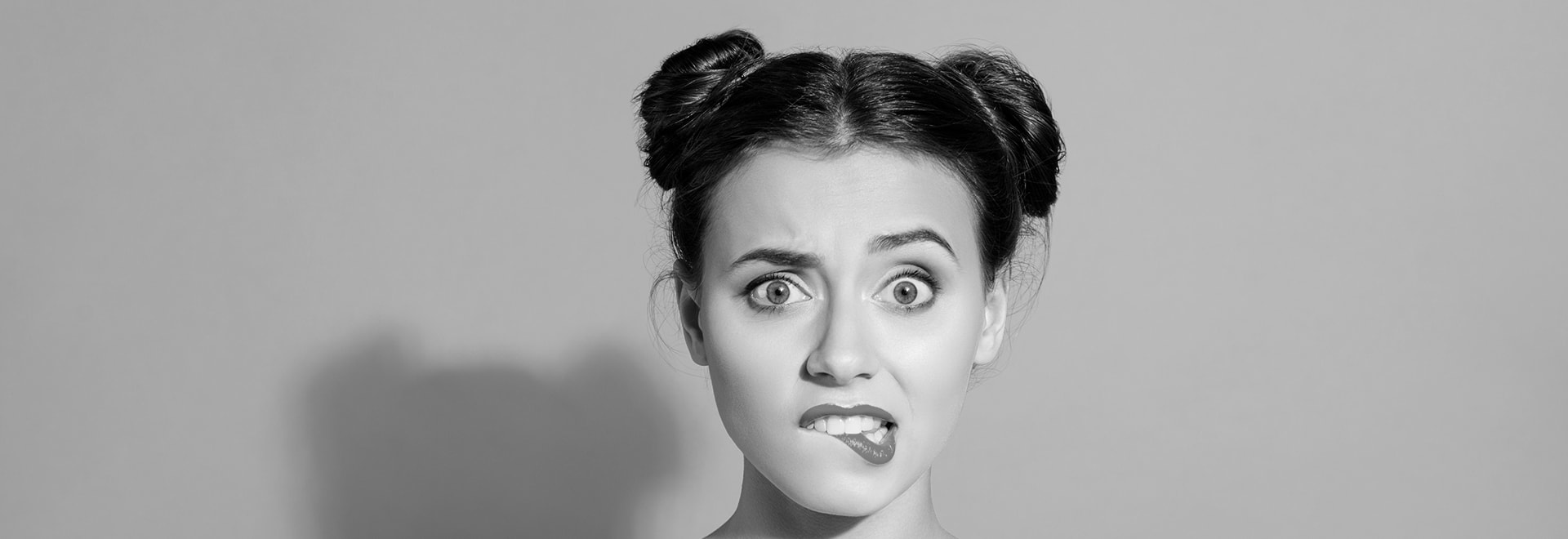The black and white photo of a confused young woman with dark hair and two buns on her head