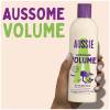 A picture of Aussome Volume shampoo Bottle in hand with claim: Aussome volume