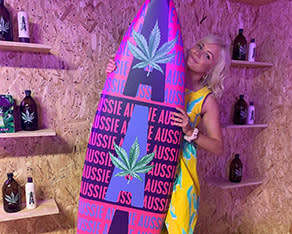 A young woman holding a purple surfboard