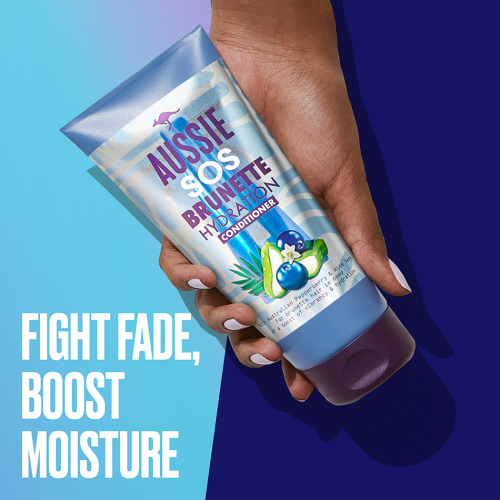 An image of a hand holding Aussie Brunette Hair Hydration Hair Conditioner and a claim: 'fight fade, boost moisture'