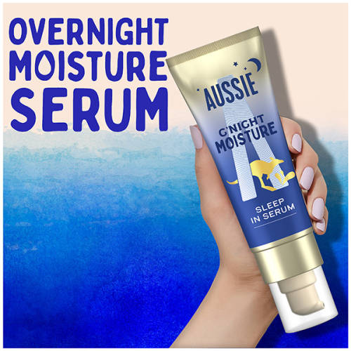 A picture of AUSSIE G’NIGHT MOISTURE HAIR SERUM tube held in hand with a text above: overnight moisture serum.