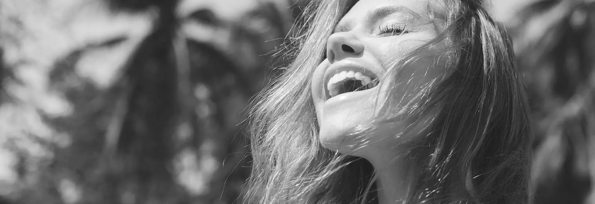 The black and white photo of a smiling young woman with long fair hair enjoying the moment