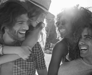 Black and white picture of 2 women and 2 men smiling
