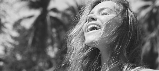 The black and white photo of a smiling young woman with long fair hair enjoying the moment