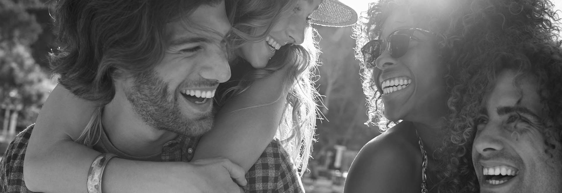 The black and white photo of 2 couples - 2 men are holding 2 women on their back