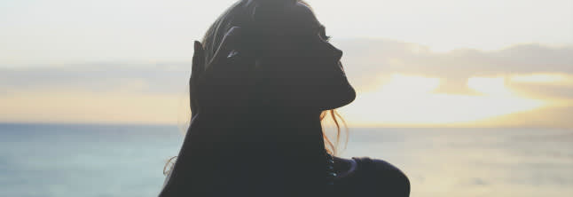 A photo of woman's shape on the sunset background