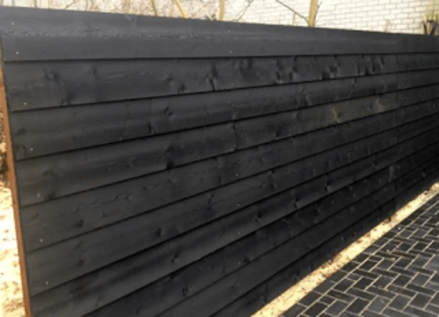 Schutting van zwarte potdekselplanken