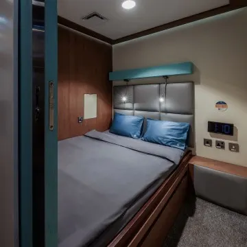Double cabin at Doha South/North featuring two single beds, reading lights, and compact storage.