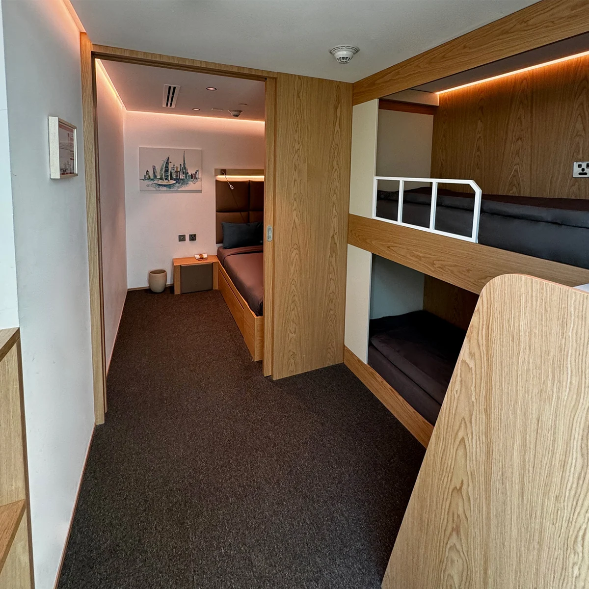 Family cabin at Terminal 3B with bunk beds, seating area, and personal storage.