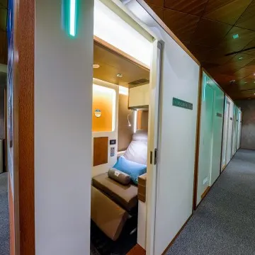 Interior of Doha South FlexiSuite showing individual sleeping pods with privacy screens and soft ambient lighting.