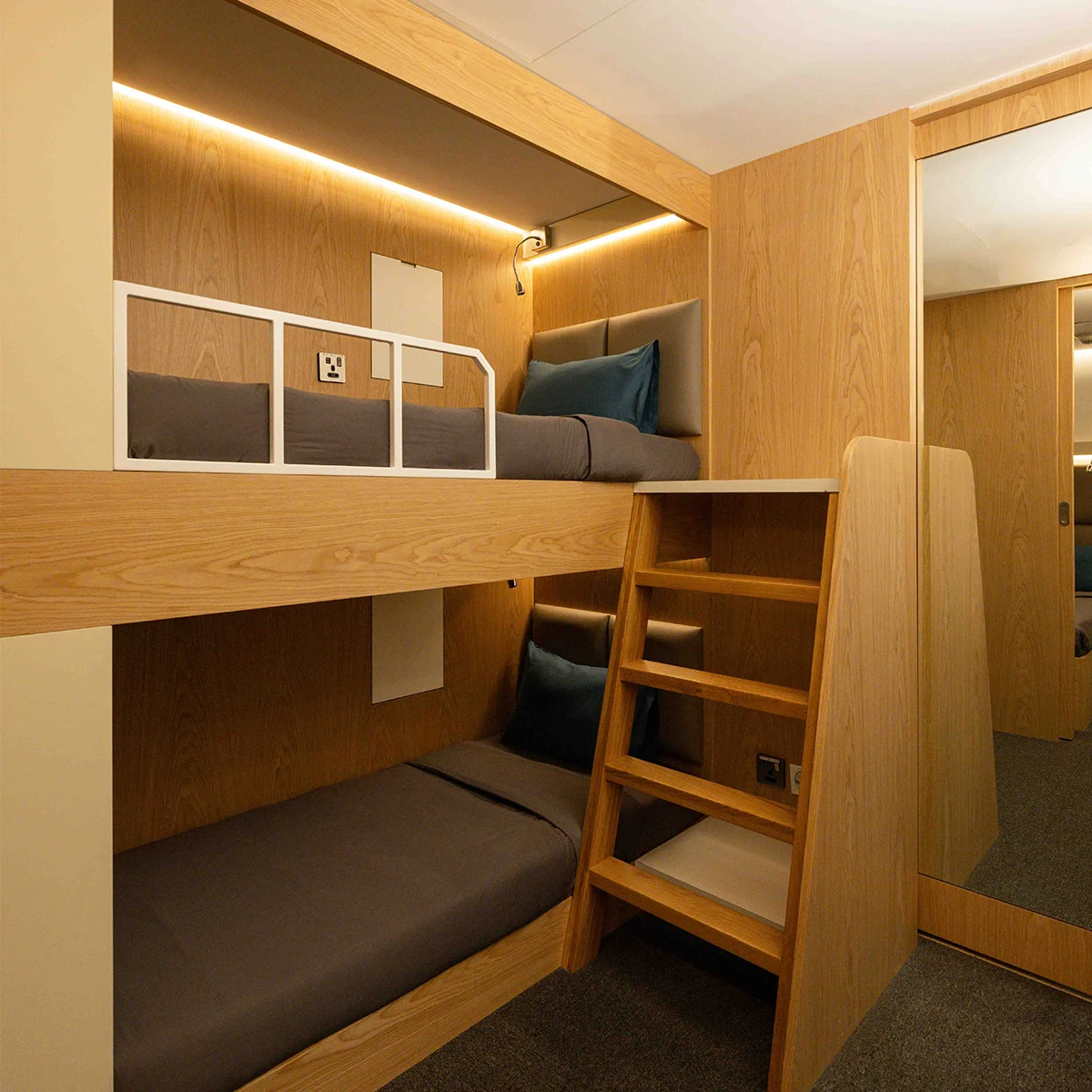 Family cabin interior with bunk beds, seating bench, and soft lighting.