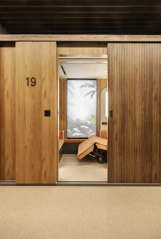 Interior view of a Sleepover sleeping pod with bed, pillow, and enclosed design.