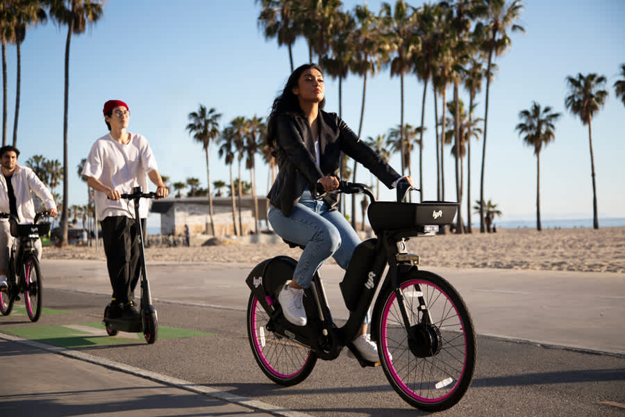 Group of people riding Lyft e-bikes near the beach. 