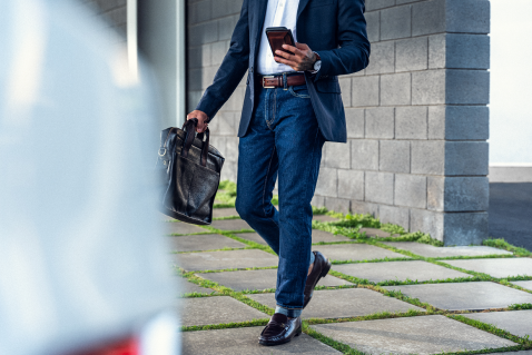 homme marchant, un téléphone cellulaire à la main 