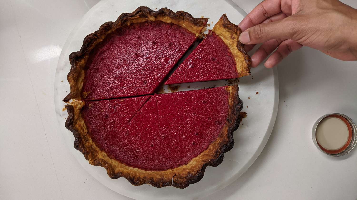 Jacob pulls a slice of freshly baked beet pie with vibrant red filling.