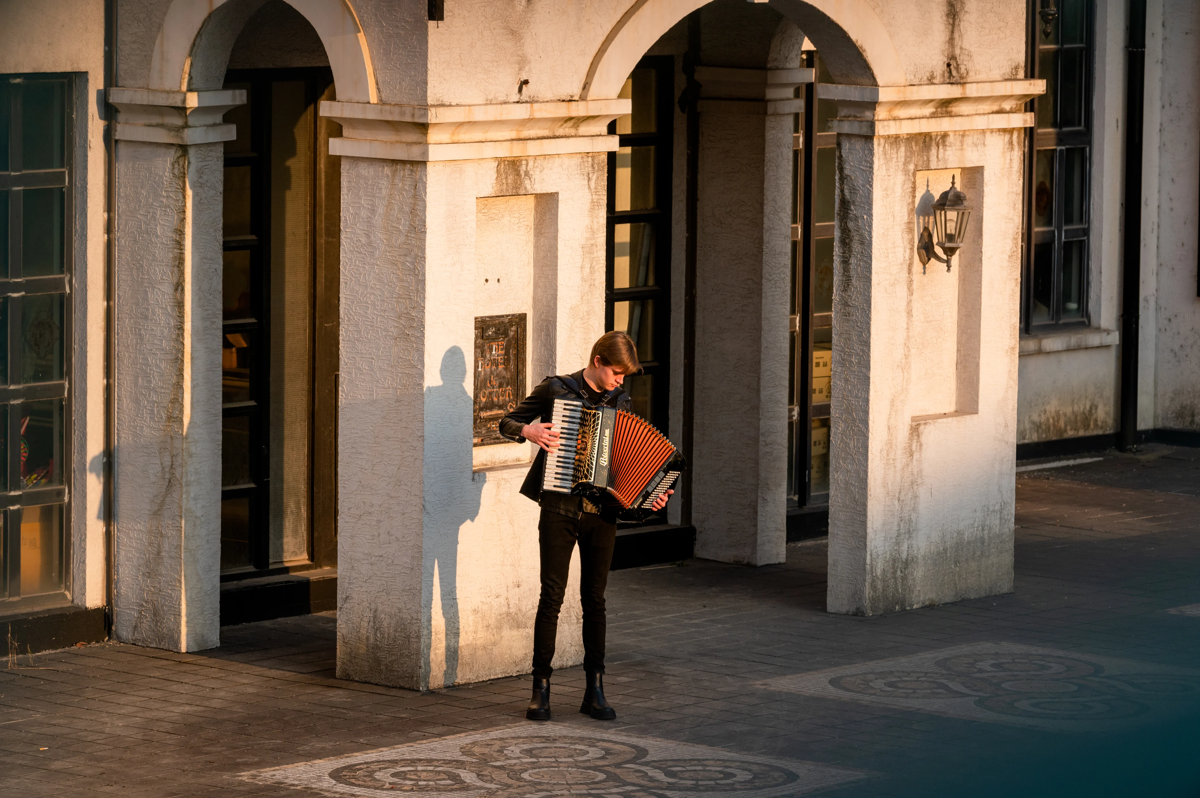 Man play accordion in front of historical building