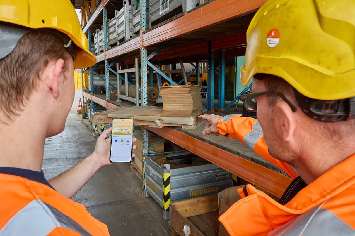 Two employees using the Heijmans app in a warehouse