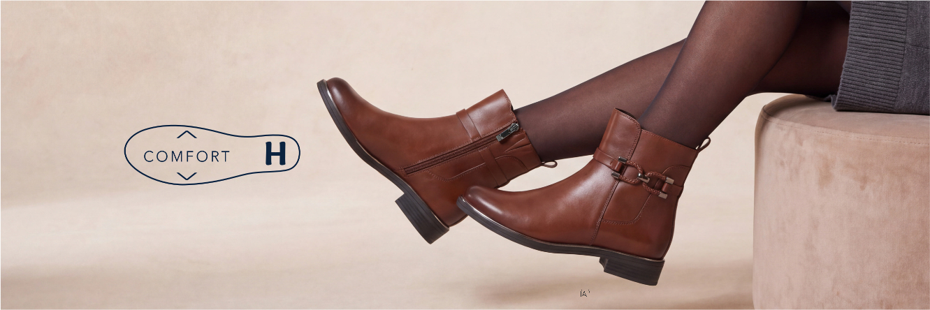 Visuel avec symbole de semelle intérieure et texte « COMFORT H » à côté d’une paire de bottines beiges à lacets, confort large.